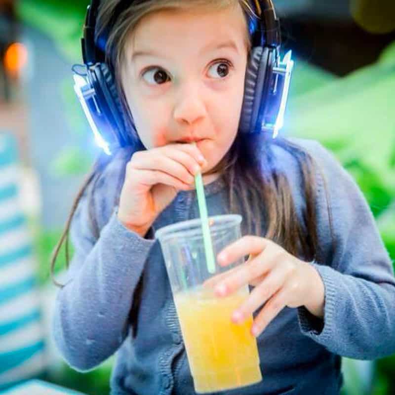 discotecabambini Girl in blue LED headphones drinking from a cup at a party