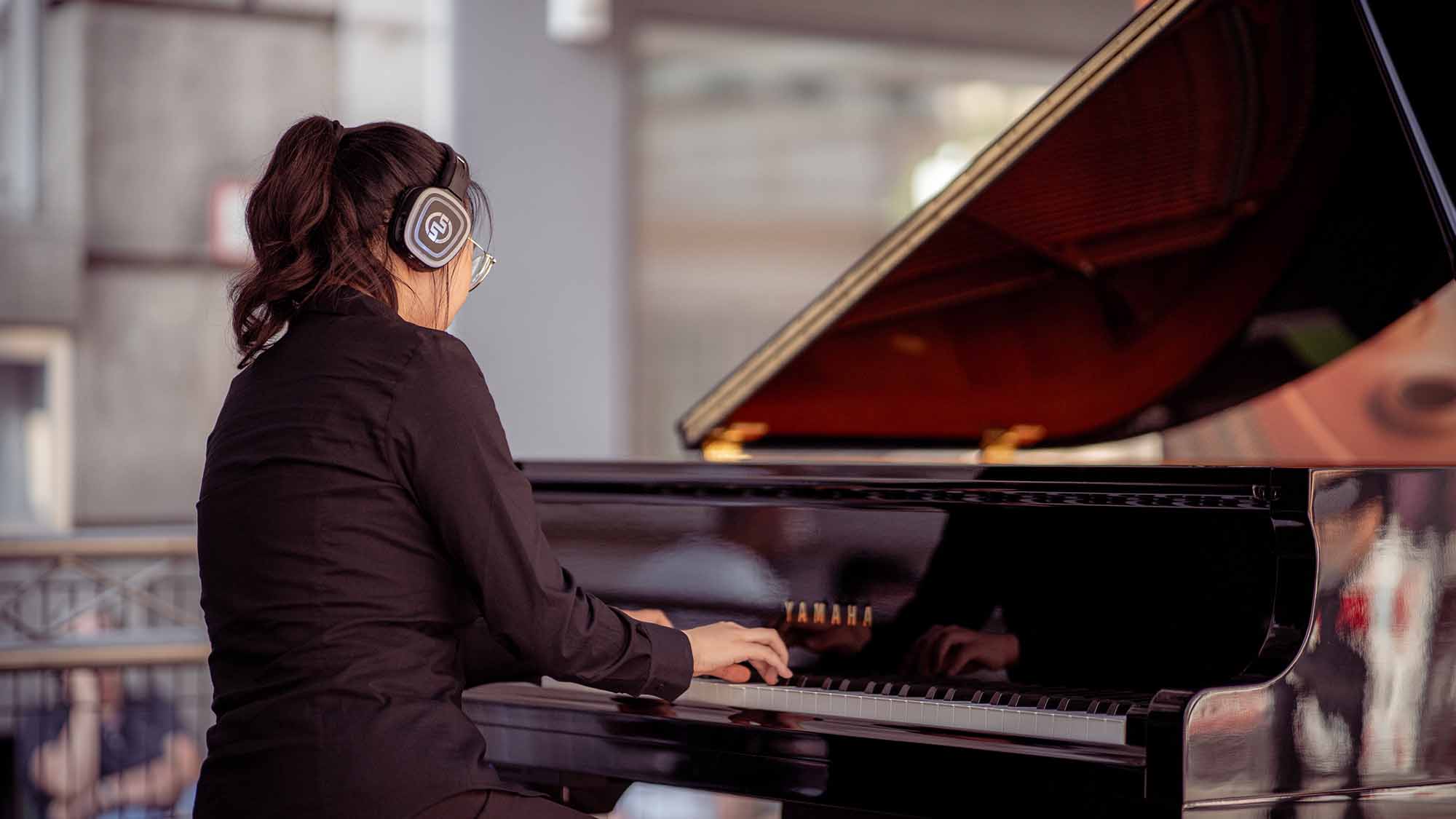 Pianista con pianoforte Yamaha Silent e cuffie wireless Silentsystem Piano concerts with wireless headphones: the complete guide
